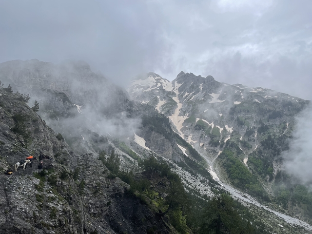 Misty mountainous landscape with patches of snow.