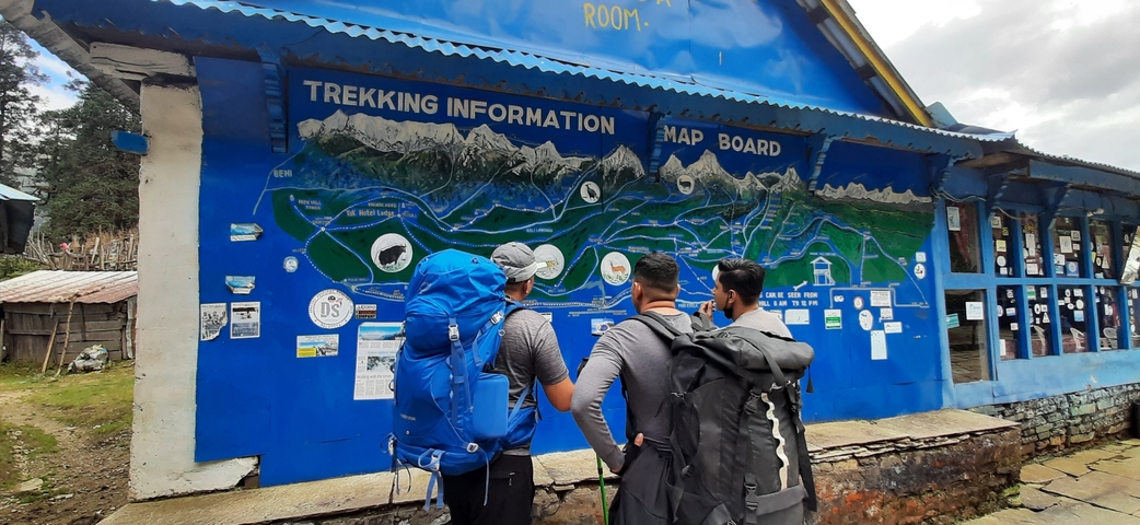 Men looking at a trekking information map board.