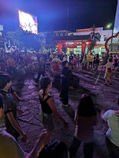       Night street party or event with a crowd.
  