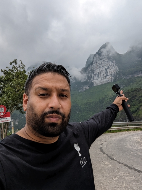 Person taking a selfie with a mountain view background.