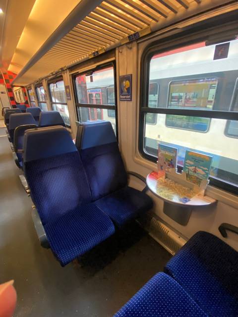 Interior of a train with blue seats.