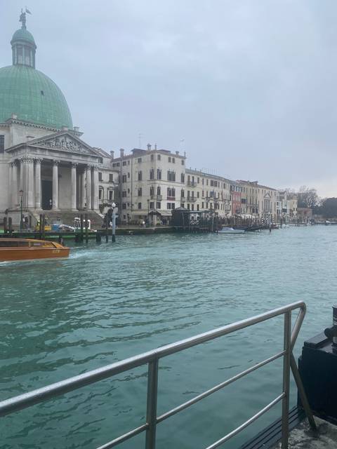 Canal view with historic buildings and water taxi in Venice.