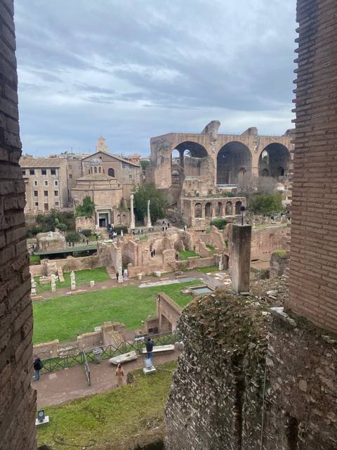 Ruins of ancient structures with people walking around.