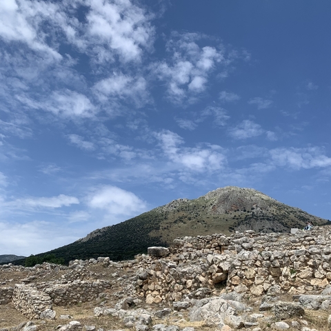       Mountain with ruins in the foreground against a blue sky.
  
