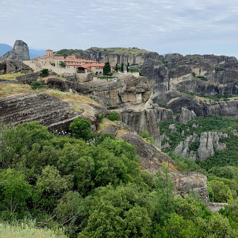       Dramatic cliffside view of a monastery on a mountain.
  