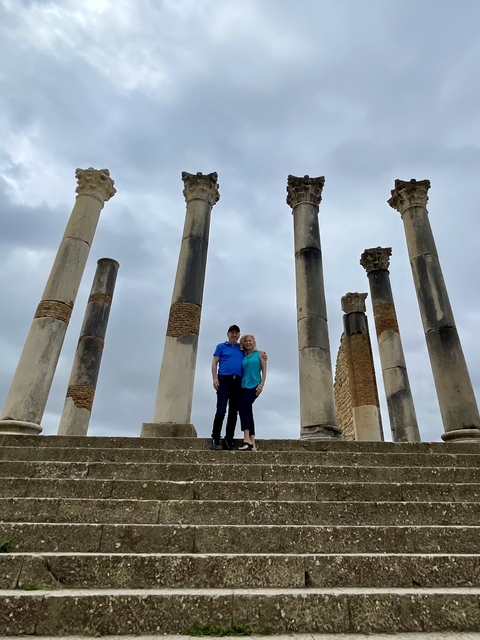 Basilica ruins with two people and cloudy sky