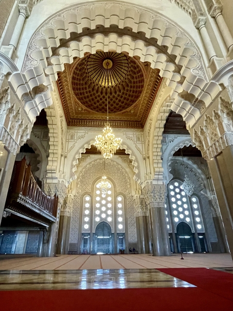 Interior of a grand mosque with ornate arches.