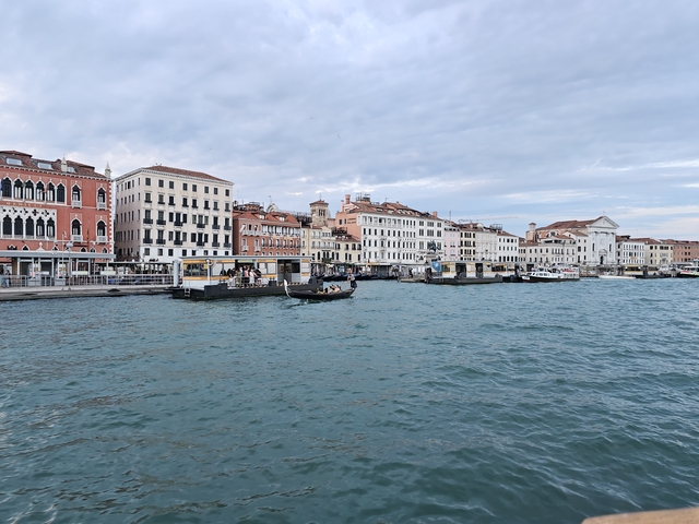 Gondolas in a canal with colorful old buildings in Venice.