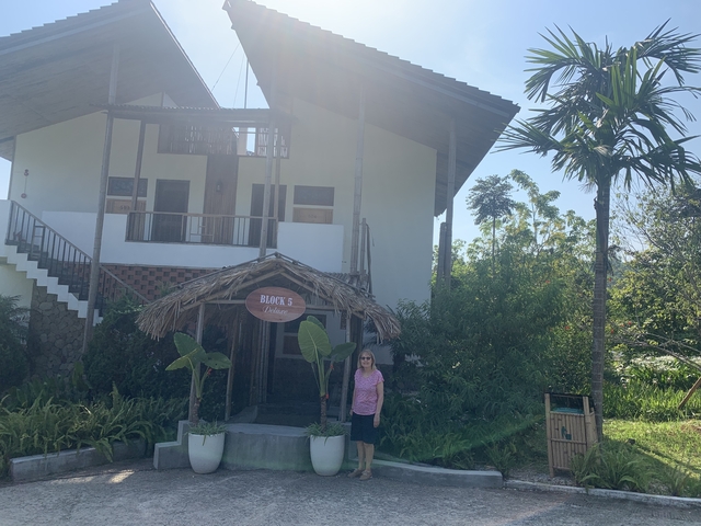 A person standing in front of a guesthouse entrance