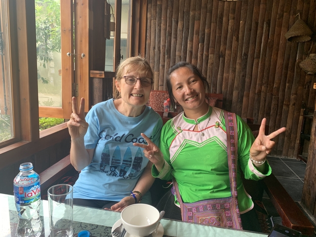 Two women sitting indoors smiling and posing