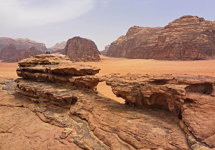 Tourists sitting on red sandstone rock formations