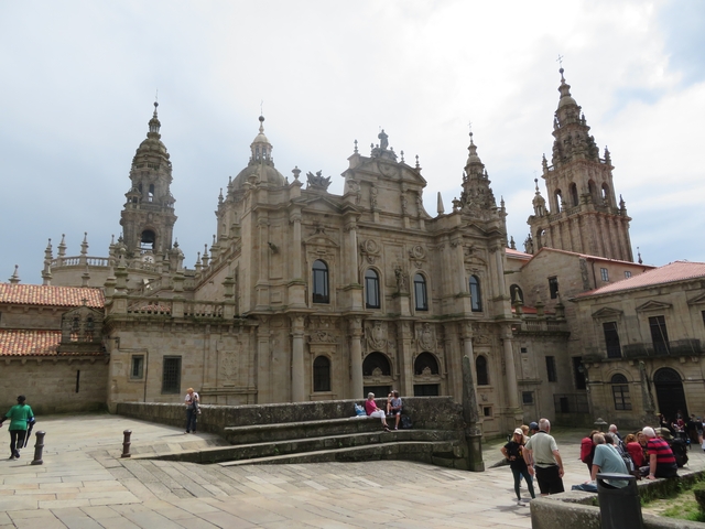       A historical cathedral with people around.
  