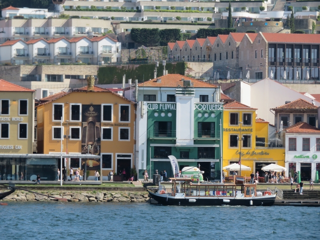       Colorful waterfront with people and a boat.
  