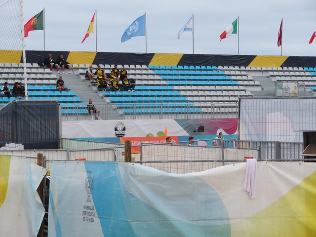       Empty stadium seating with some spectators.
  