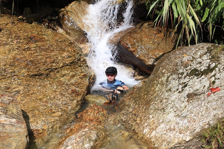       Person in a waterfall enjoying the water.
  