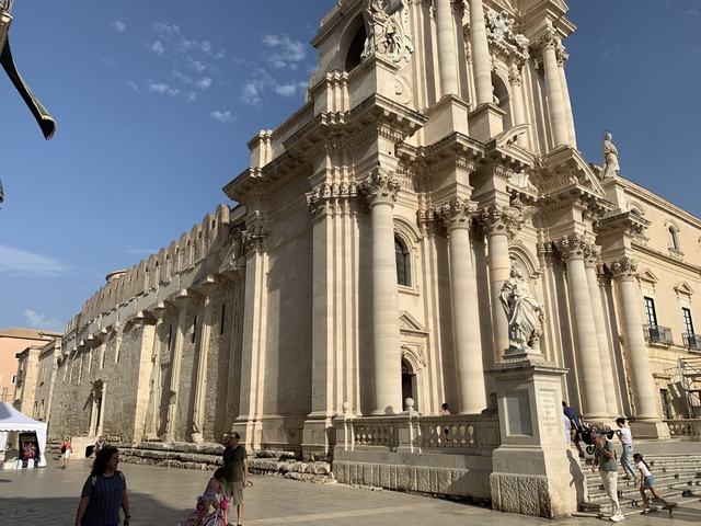       Neoclassical building facade with columns and statues.
  