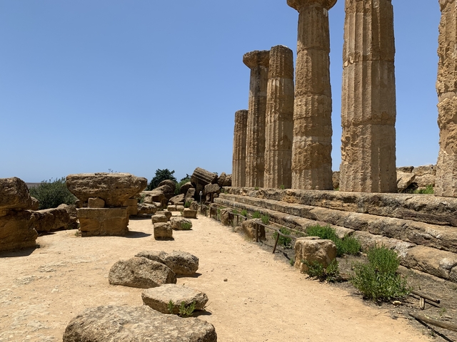       Ancient ruins with columns and a clear blue sky.
  