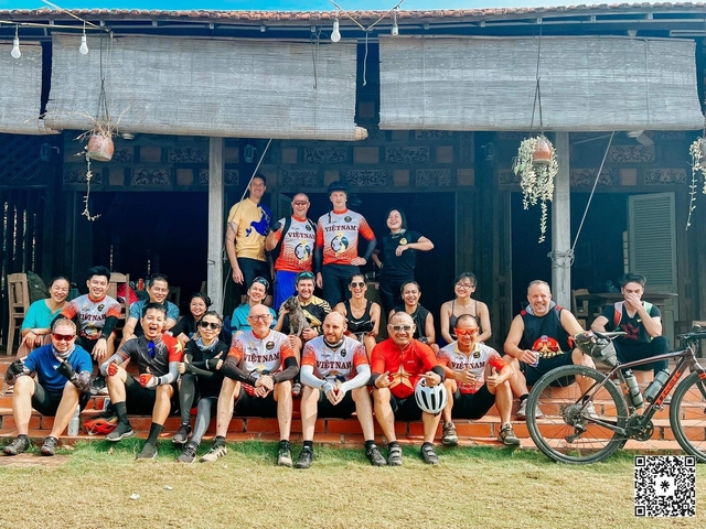 Large group posing in front of a traditional building.