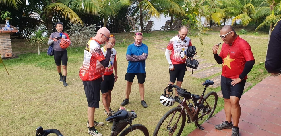 Cyclists in Vietnam jerseys gathered with bicycles.
