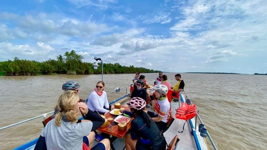 People enjoying a meal on a boat in a river.
