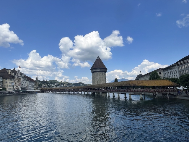       A picturesque bridge extending over a serene waterway with a tower.
  