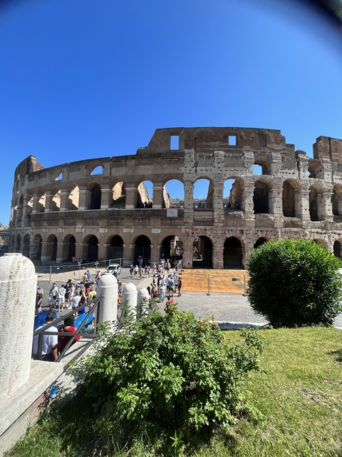       People walking outside near the Colosseum.
  