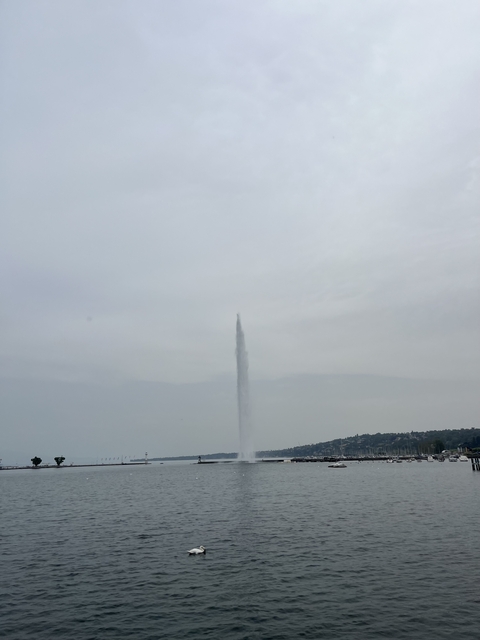       A tall water fountain shooting into the sky.
  