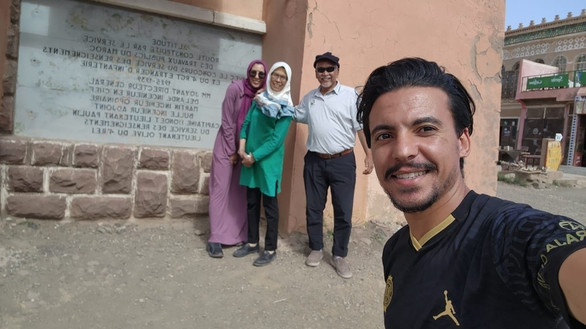       Group of people taking a selfie next to a historical monument.
  