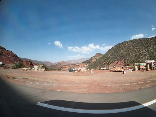       Vast landscape with a blue sky, mountains, and desert terrain.
  