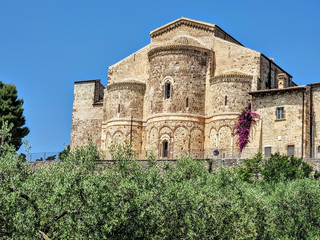 A historic church with detailed brickwork and vibrant plants.