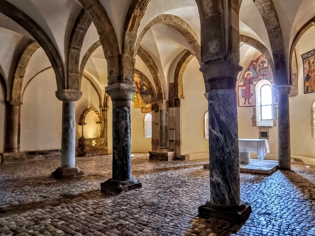 Interior of a historical church with stone columns and arches.