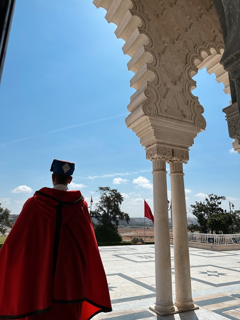       Person in traditional robe near ornate columns
  
