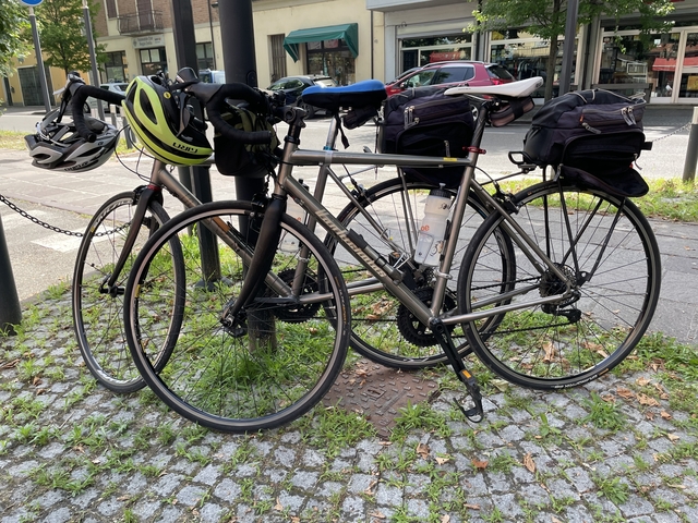 Two bicycles parked near a post