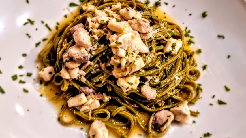 Pasta dish with chunks of meat and herbs