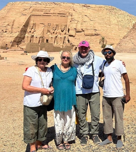       Group of people posing in front of Abu Simbel.
  