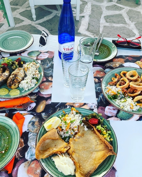       Plates of diverse seafood dishes served on a table.
  