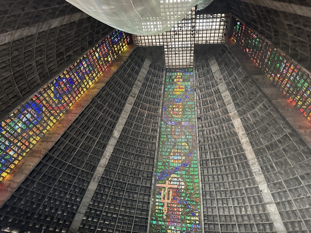 Interior of a cathedral with stained glass windows and a high ceiling.