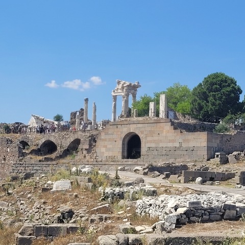       Ancient ruins on a hill with scattered columns.
  