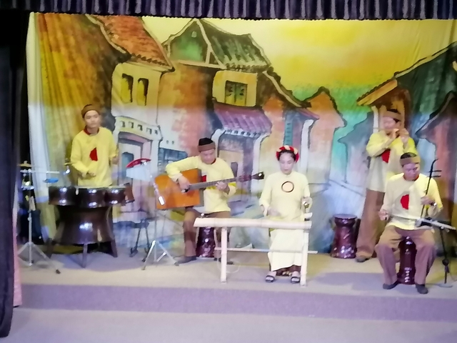       Blurred image of people performing traditional music.
  