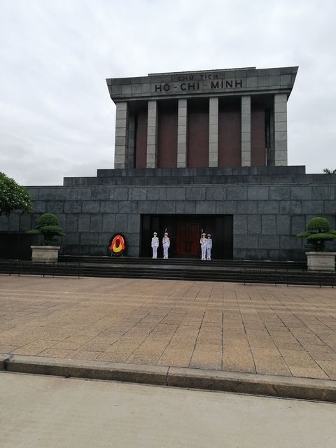       Guards in formal white uniforms standing at attention.
  