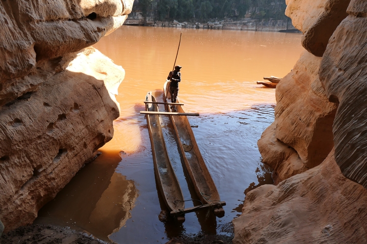       Person on a canoe in a narrow river canyon.
  