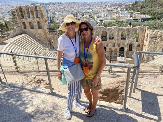 Two people posing by ancient ruins in Athens