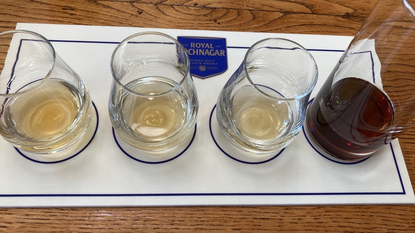 Four glasses of whisky on a tasting mat.