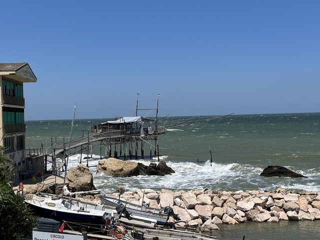 Traditional fishing platform on a rocky shoreline.