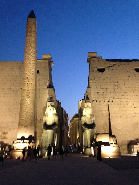       Blurred view of ancient temple ruins under a dusk sky.
  