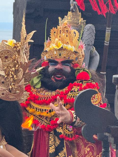 A colorful and ornate costumed figure during a performance.