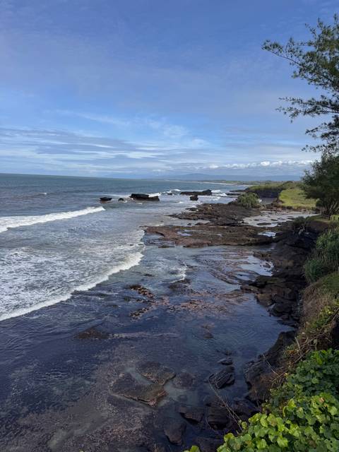 A rugged seaside landscape with rocks and waves.