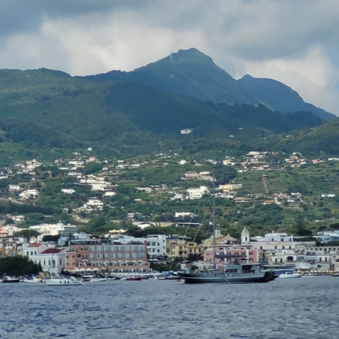       Hillside town with scattered houses and lush greenery.
  