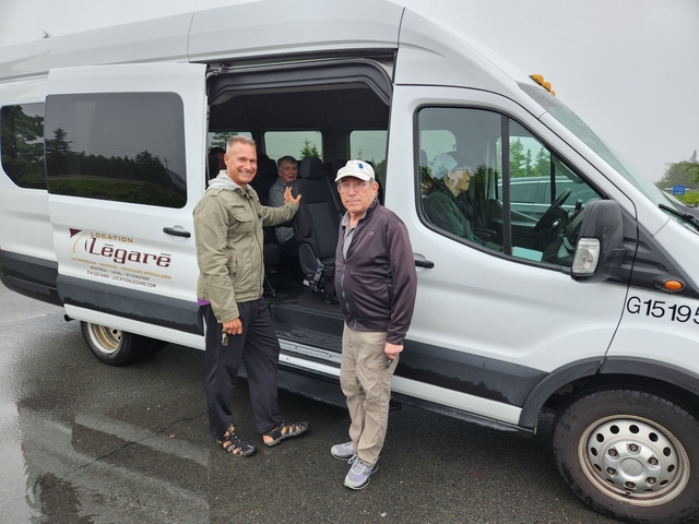      Group of people by a van during a travel stop.
  