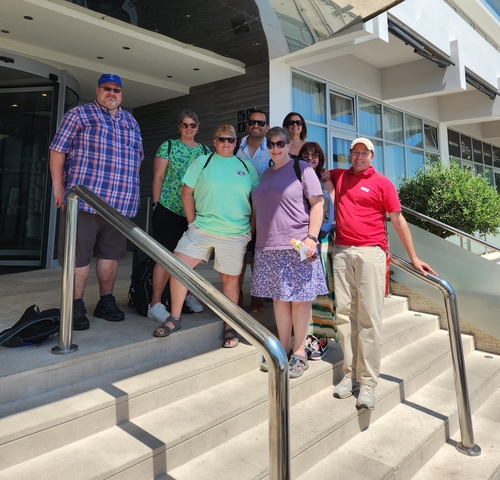 A group of people posing together on a staircase.